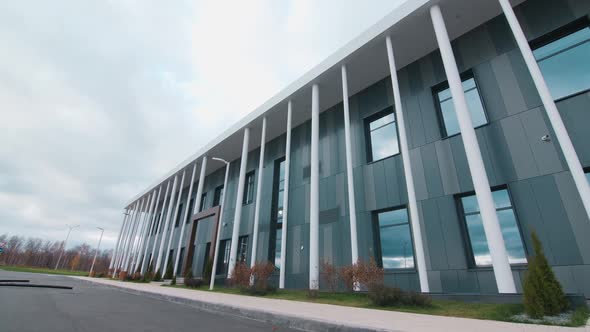 Corporate Building with White Poles and Arch on Street