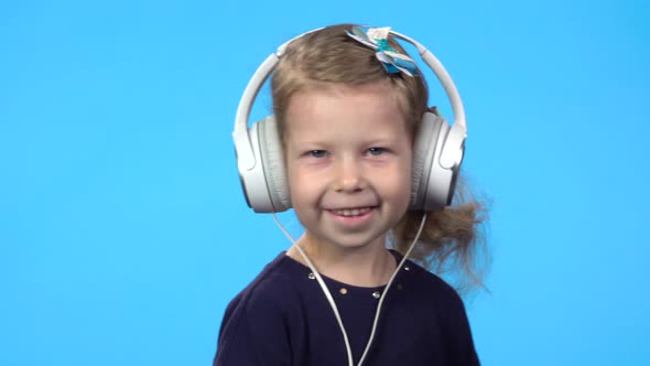 Child Is Looking at the Camera and Smiling. Blue Background