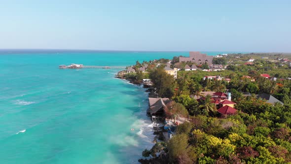 Aerial Tropical Landscape of Zanzibar Waves Hit Reef on Hotels Coastline Palms