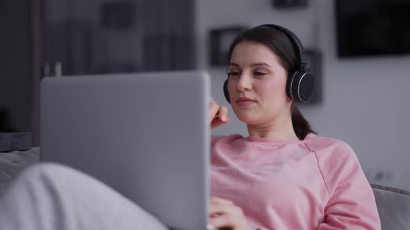 Portrait of a Woman Working with Laptop and Listening Music By Headphone