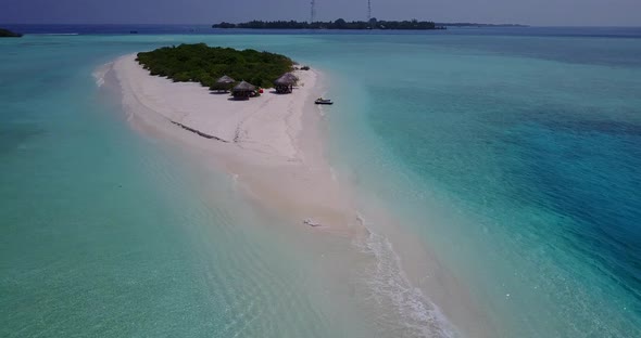 Tropical fly over tourism shot of a sandy white paradise beach and blue water background 