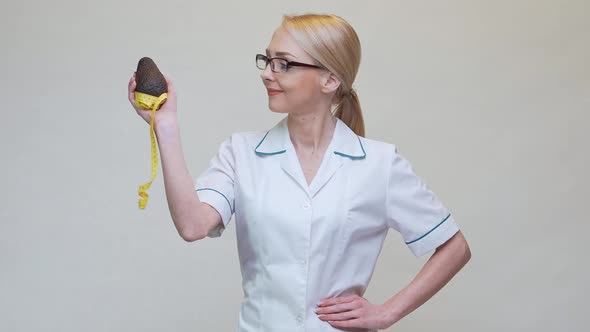 Nutritionist Doctor Healthy Lifestyle Concept - Holding Organic Avocado Fruit and Measuring Tape