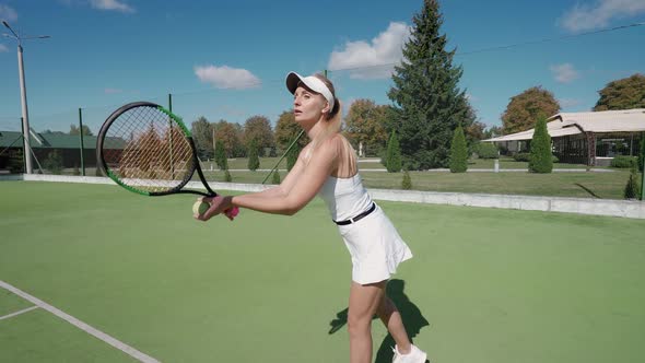 Pro Tennis Player Hits the Ball with a Racket Practice Game on the Tennis Court Female Serving Ball