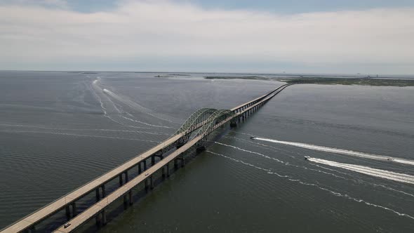 An aerial view of the Great South Bay Bridge on a cloudy morning. The drone camera truck right and p