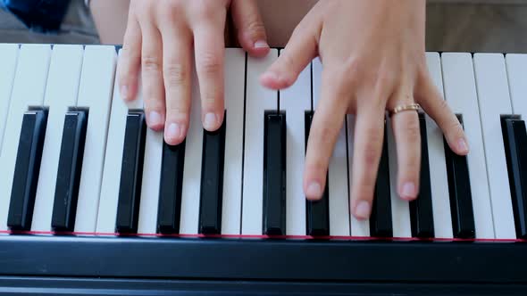 Young woman playing electronic piano at home