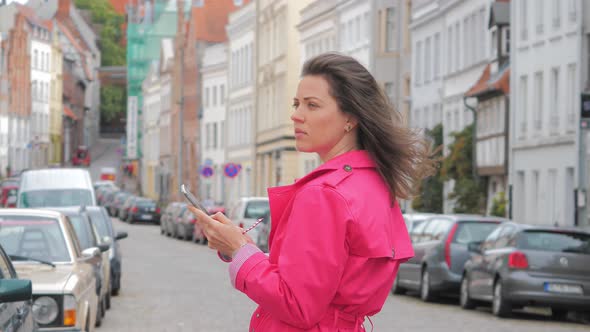 Young Woman Using Application on the Mobile Phone To Find the Needed Address