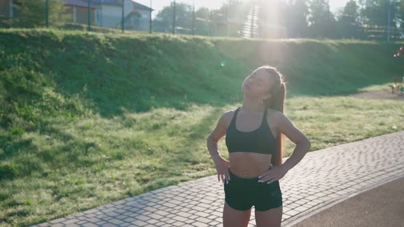 Young Slim Woman Warming Up at Stadium