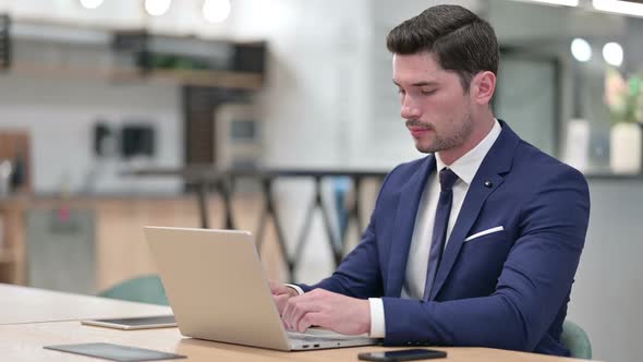 Excited Businessman Celebrating Success on Laptop in Office