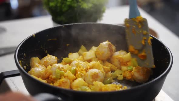 Crop person stirring vegetable stew with mushrooms