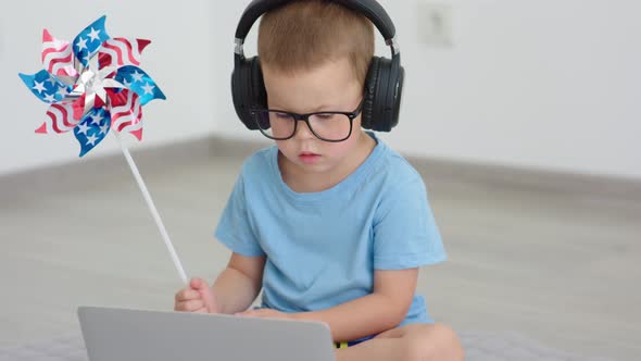Celebrating Independence Day Holiday Online Child in Headphones Holding Pinwheel