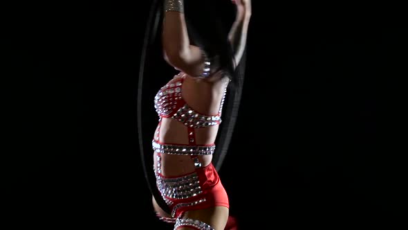 Girl Athlete Performs Acrobatic Twine on the Air Hoop. Black Background. Slow Motion. Cloe Up