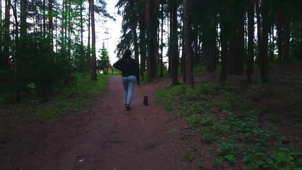 Girl walking with dog in forest