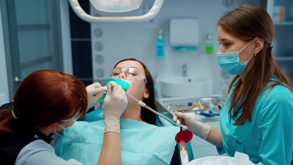 Young woman treats her sick tooth in clinic