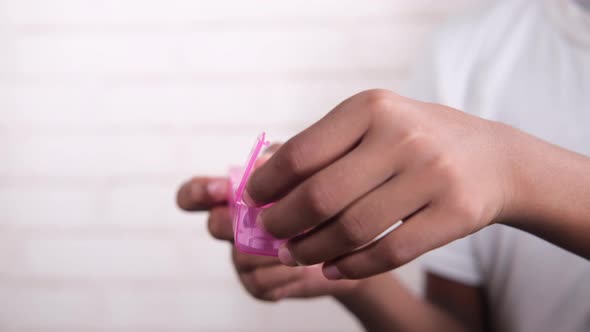 Man's Hands Taking Medicine From a Pill Box