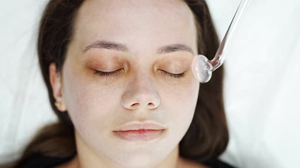 Beautician Uses the Darsonval Device on the Client's Face