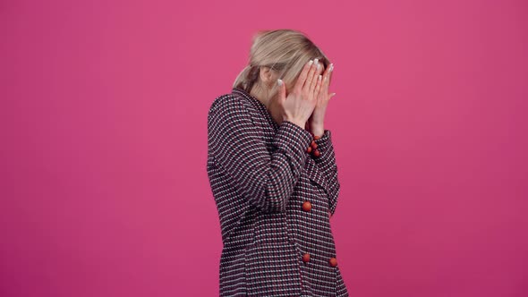 The Young Woman is Terrified and Scared She Looks Into the Room and Covers Her Face with Her Hands