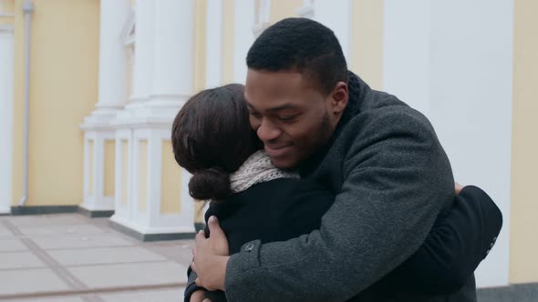 Happy African American Man and Woman Hugging Meeting Unexpectedly Outdoors Slow Motion