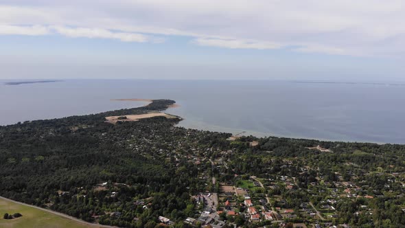 Aerial view of the coastline of Sejerøbugten with hills, fields and ocean.