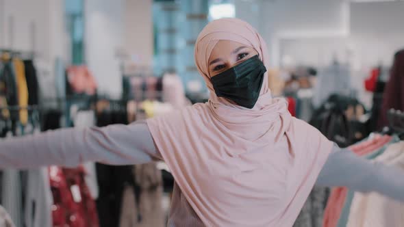 Happy Carefree Active Funny Young Arab Woman Shopper in Hijab Wearing Protective Medical Mask Moving