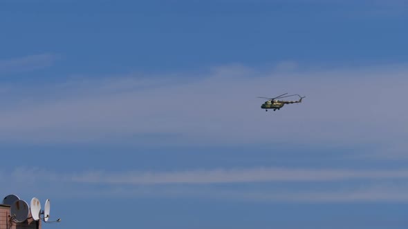 Helicopter Flies in the Blue Sky Low Above the Ground