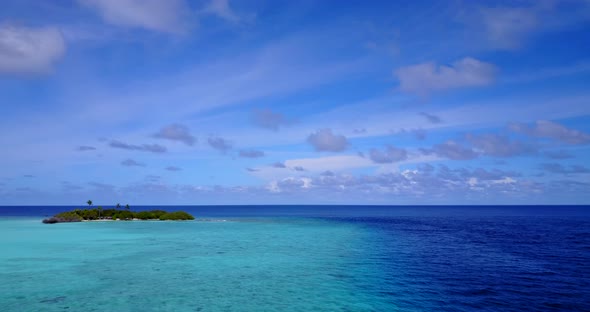 Tropical flying copy space shot of a white sandy paradise beach and aqua blue water background in 4K