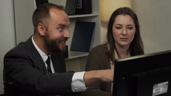 Male office worker works with female office worker discussing a project