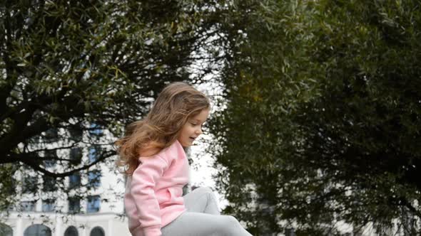 Little Girl Playing on Big Rocks in Summer