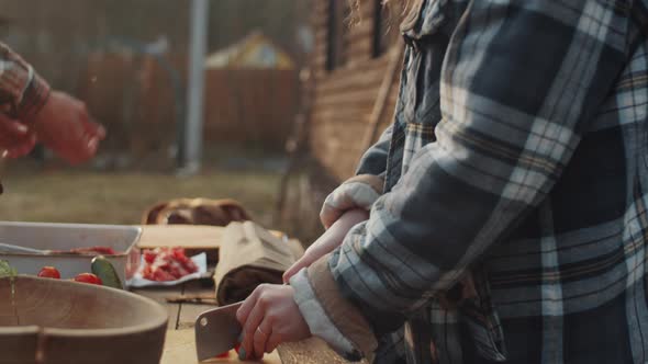 Woman Cutting Vegetables for BBQ while Husband Feeding Dog