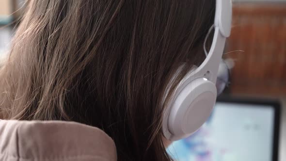 A Young Girl Listens to Information Remotely