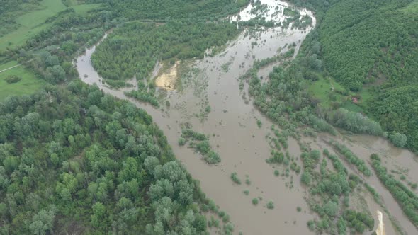 Above overflow of water from river by the forest 4K drone footage