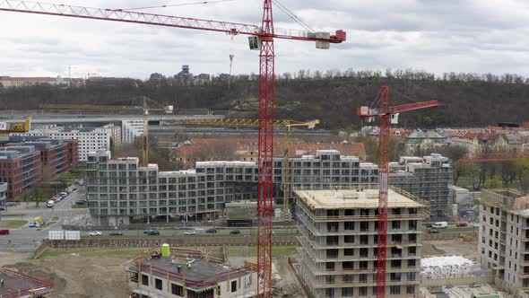 Red tower cranes at construction site in Prague, pedestal drone shot.