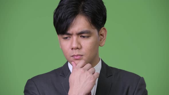 Young Sad Asian Businessman Thinking