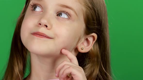 Baby Is Looking at the Side, She Is Thoughtful. Green Screen. Close Up