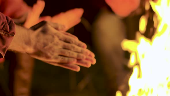 Close Up of Man Warming Up His Hands at Camp Fire