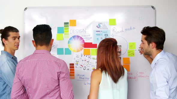 Business executives writing on white board with marker