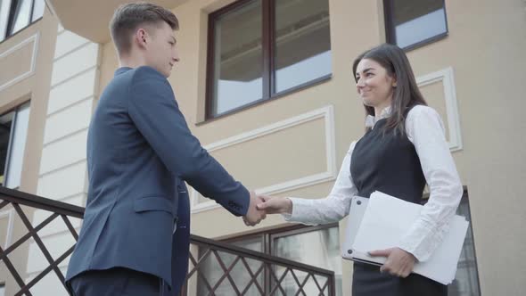 Portrait Cute Young Woman and Confident Man in Formal Wear High Five Together on the Terrace