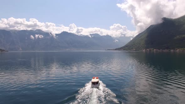 Passenger Ferry Sails Along the Kotor Bay with the Mountains in the Background