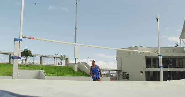 Mixed race athlete doing high jump