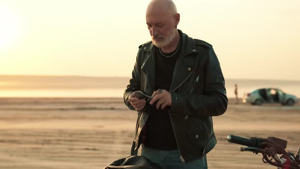 Tattooed biker man putting of his leather jacket