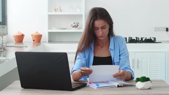 Frustrated Young Woman Reading Paper Letter with Bad News