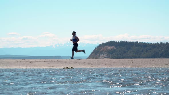 Man Jogging Sandy Beach Epic Nature Background alt