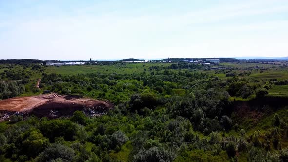 Aerial drone view of a flying over the technogenic landscape among rural agricultural fields.