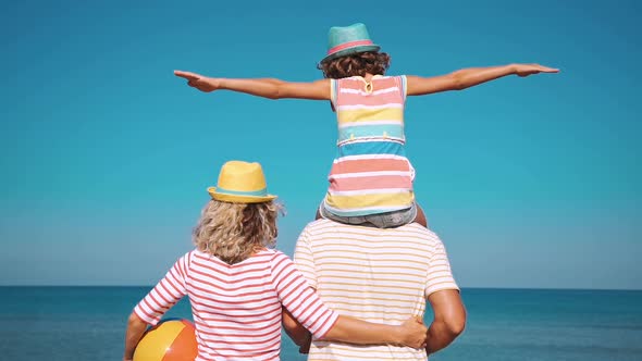 Father, Mother and Child against Blue Sea and Sky Background