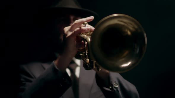 Male Musician in Classic Suit Plays Musical Trumpet in Studio on Black Background Closeup of Trumpet