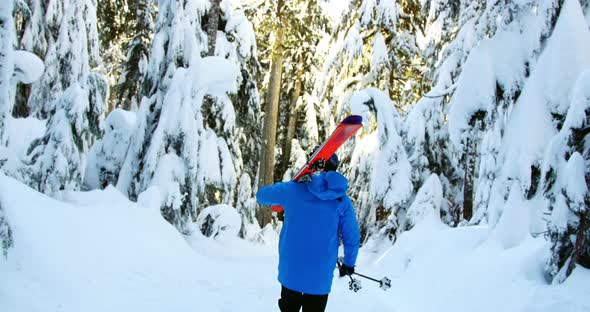 Rear view of person walking with snowboard and ski pole 4k