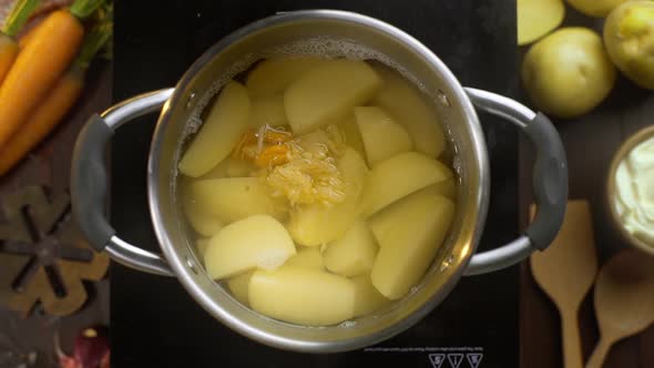 Flat Lay Video: the Cook Puts Blanched Vegetables To the Potatoes in the Boiling Water, Tabletop