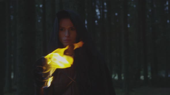 Woman walking in the forest with a fire torch