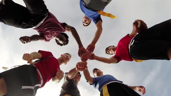 A group of young men playing flag football on the beach.