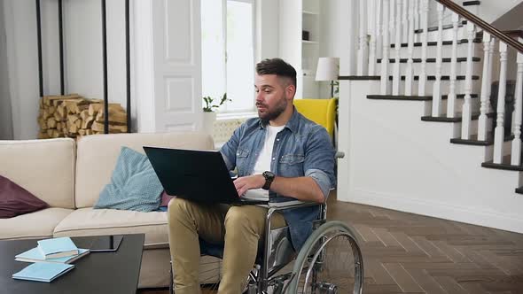 Bearded Guy in Wheelchair Having Video Call on Laptop with Relatives or Friends