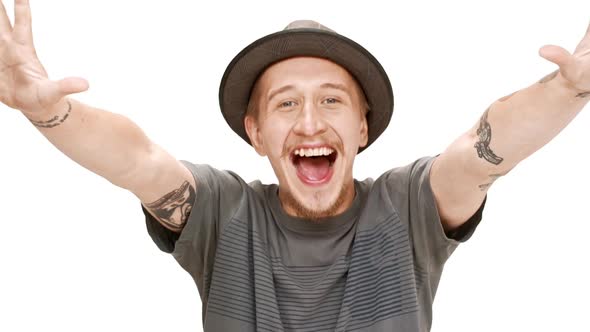 Young Handsome Man in Hat Smiling Rejoicing Over White Background